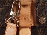 a close up of a louis vuitton bag with a keychain on it