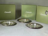 three silver dishes sitting on top of a table next to a green box