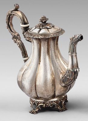 une théière ancienne en argent, dotée d'une anse en forme d'oiseau et posée sur un socle