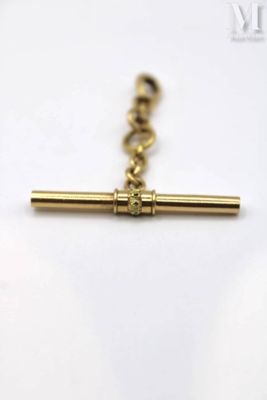 a close up of a gold cross on a chain on a white surface