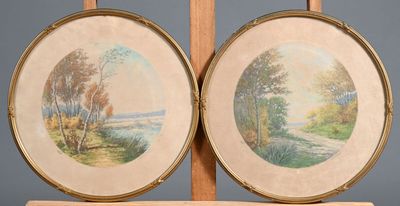 Deux tableaux encadrés représentant des arbres et une rivière sont posés sur un chevalet en bois.