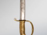 a gold and silver dagger with a handle on a gray background