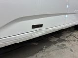 a close up of a white car with a sticker on it