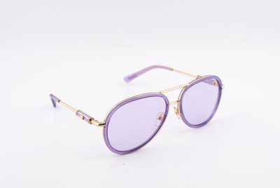 une paire de lunettes de soleil violettes posée sur une surface blanche