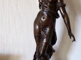 a statue of a woman holding a knife on top of a table