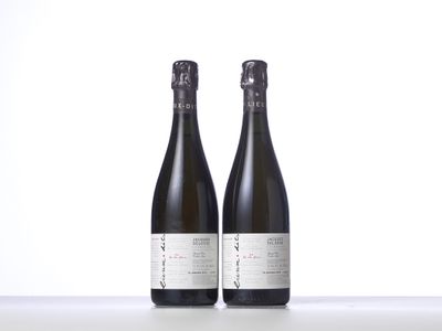two bottles of wine sitting on top of a table next to each other