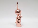 a small copper figurine of a person holding a book