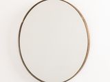 a round mirror hanging on a wall next to a white wall