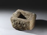 un objet en pierre posé sur une surface blanche