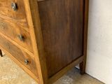 a small wooden chest of drawers on the floor