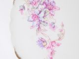 a plate with flowers painted on it on a table