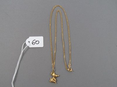 un gros plan sur un collier en or orné d'un petit éléphant
