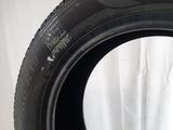 tire on a white surface with a white curtain in the background