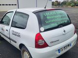 a white car parked in a parking lot with a sign on the back of it