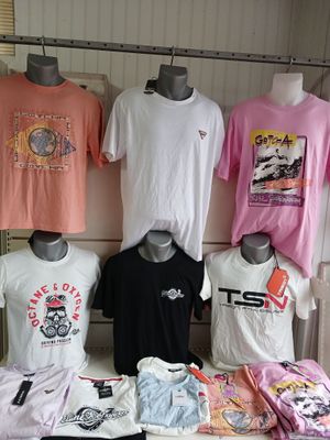 many t - shirts on display on a table in a store