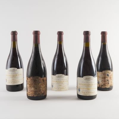 quatre bouteilles de vin sont alignées sur une surface blanche