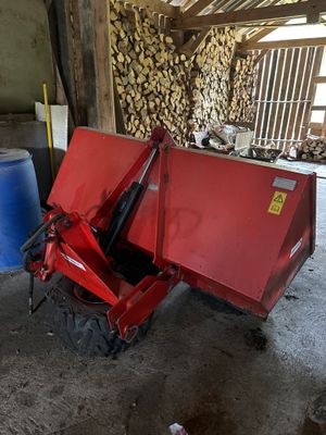 une benne basculante rouge qui est garée dans une grange
