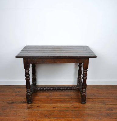 an old wooden table on a wooden floor in a white room