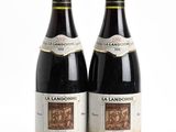 two bottles of wine sitting next to each other on a white surface