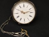 une montre de poche en argent avec des chiffres romains