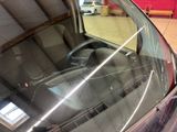 a car that has a broken windshield in a garage