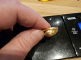 une personne tenant une bague en or posée sur un balancier