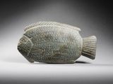 an image of a stone figurine of a fish on a gray background