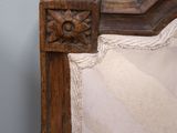 a bed with a wooden headboard and a white pillow
