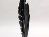 black and white sculpture of a feather on a marble base