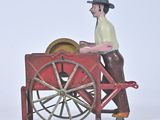 a toy of a man pushing a cart with a wheel