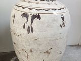 a large white vase sitting on the floor next to a wall