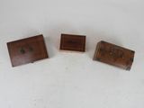 three small wooden boxes sitting on top of a white surface