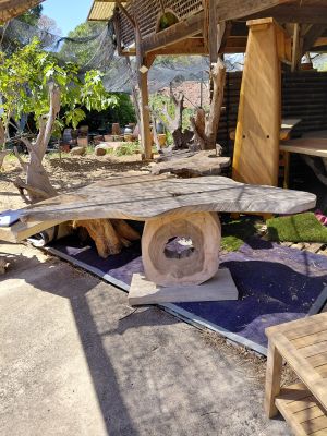 a wooden table and chairs in the yard of a house