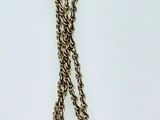 a silver necklace with a knot on it on a white surface