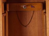 a wooden cabinet with a chain hanging from it ' s door