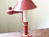 a red lamp that is sitting on a wooden table
