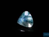 un gros plan d'un diamant bleu et blanc sur une surface noire