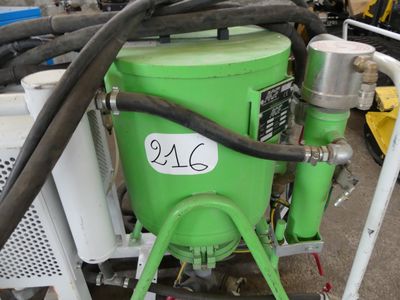 une image représentant une machine verte à laquelle est raccordé un tuyau