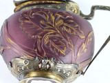 a purple vase with a gold decoration on it