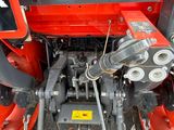 a red tractor that is parked on the side of the road
