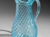 a blue glass pitcher that is sitting on a table