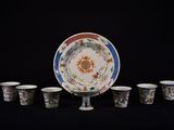 six tasses et une soucoupe posées sur une table