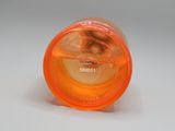 un gobelet en plastique orange avec un couvercle posé sur une surface blanche