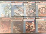 six books on a table with a picture of a man and a plane in the background