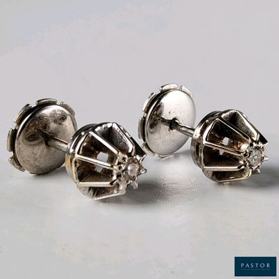trois paires de boucles d'oreilles à clous en argent posées sur une surface blanche