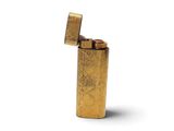 un briquet doré posé sur une surface blanche