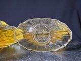 two yellow glass dishes sitting on a table