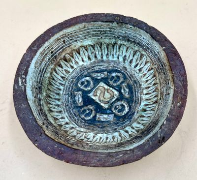 a blue bowl with a design on it sitting on a table