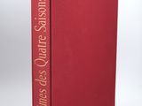 a red book sitting on top of a white table next to a lamp
