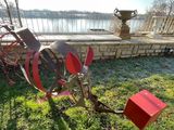 a metal sculpture that is on the grass by the water